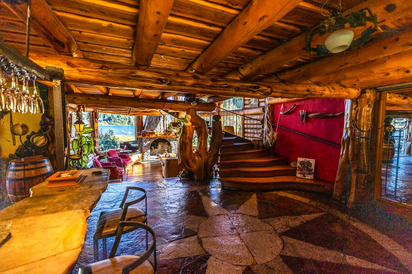 Interior rústico de un lodge con chimenea y vista al lago.