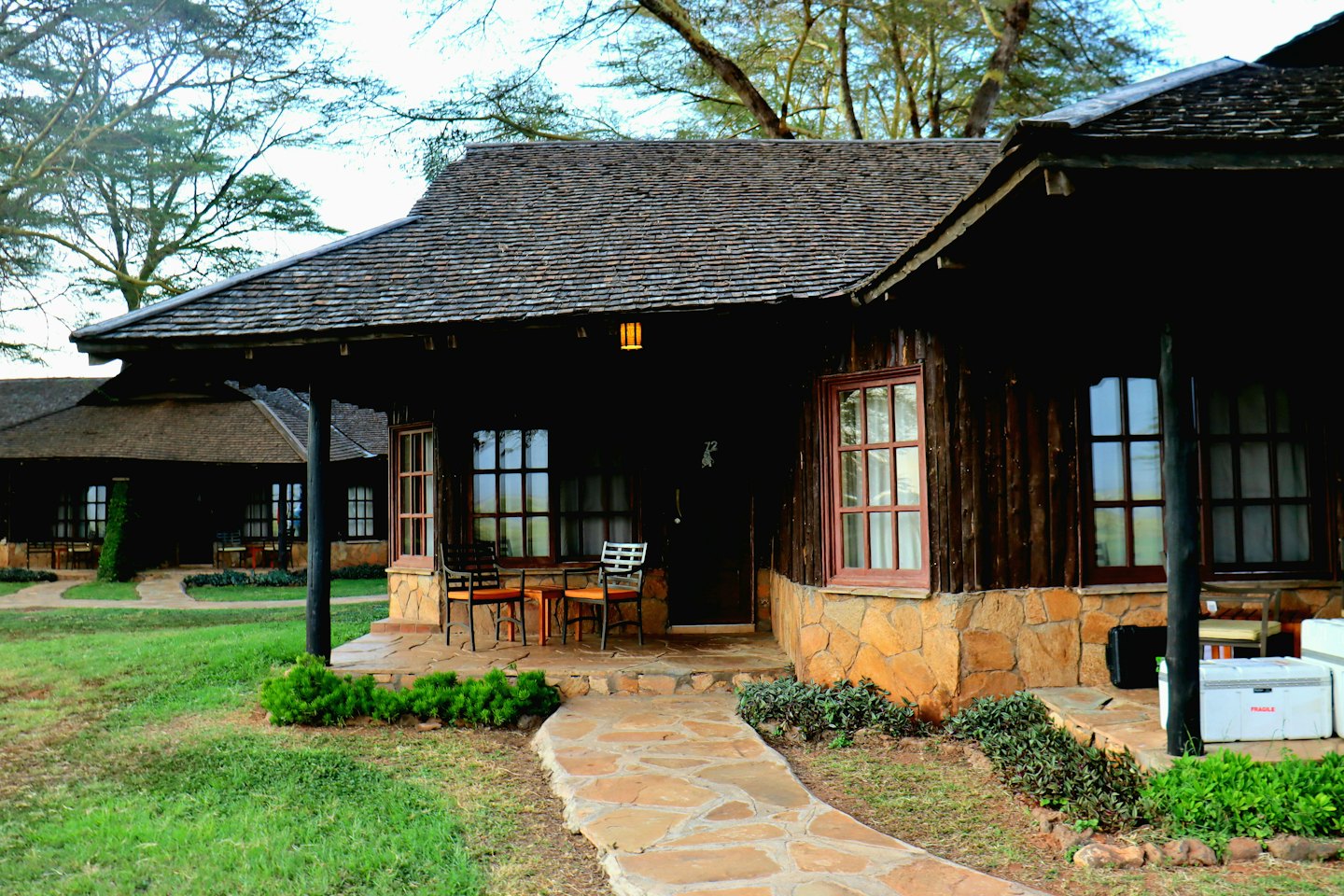 Cabañas rústicas de madera se encuentran en un césped verde.